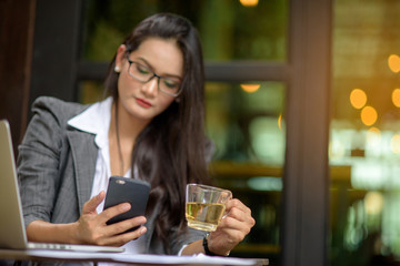 Young female freelancer checking email on cell during tea break. Business concept.