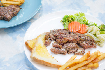 Grilled steak with french fries and vegetables and toast