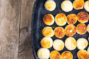 Sweet little fried cheesecakes in frying pan