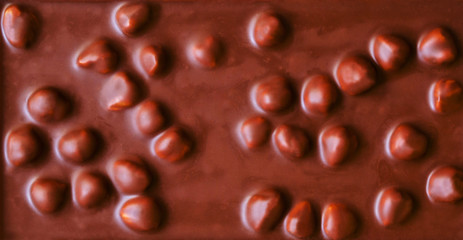 Dark chocolate with nuts as background