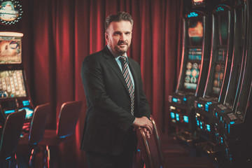 Elegant man near slots machines in a luxury casino interior