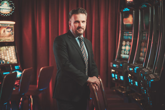 Elegant Man Near Slots Machines In A Luxury Casino Interior