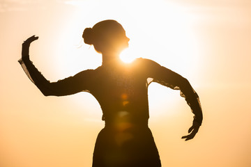 Woman dancing at sunrise