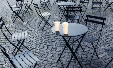 Tables and chairs on pavement in early morning