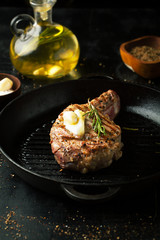 Grilled beef bone with salt, spices, rosemary and lemon in a frying pan