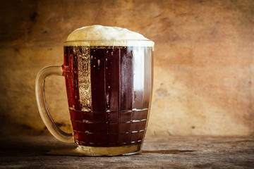 Beer in mug on rustic wooden background