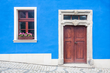 Downtown retro blue paint building door and window background.
