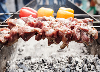 Grilled kebab cooking on metal skewer. Roasted meat cooked at barbecue. with Red and yellow Bell pepper