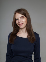 Beautiful brunette in black on a gray background