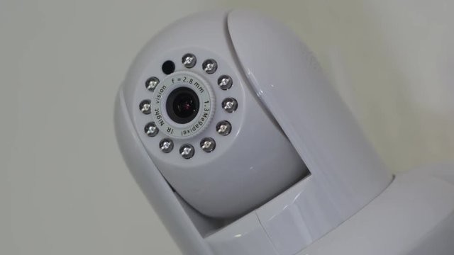 Close up of a High Definition home security camera panning and tilting, moving around to get different views or follow something in the room.