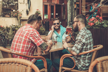 Good old friends drinking beer in a pub