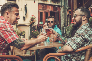 Good old friends drinking beer in a pub
