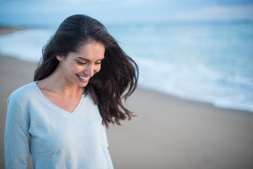 Fototapeta na wymiar Portrait of a brunette with long hair walking on the beach