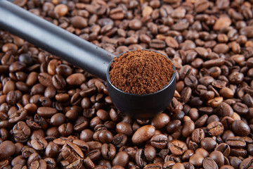 Spoon for ground coffee machine on the background of grains. 