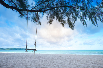 wooden swing on the blue sea in the morning , daylight ,background