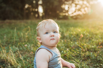 Little adorable baby boy at sunset summer portrait