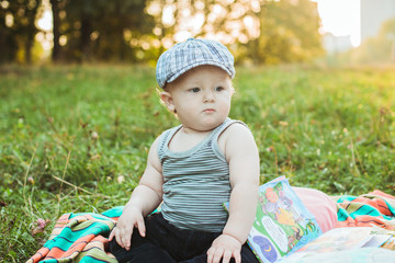 Little adorable baby boy in a hat at sunset summer portrait