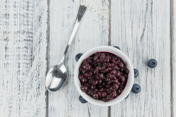 Portion of Blueberries (preserved) on wooden background, selective focus