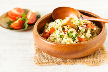 Delicious homemade vegetarian bulgur dish with vegetables and fresh herbs