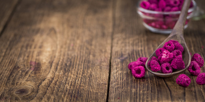 Portion of Raspberries (dried) on wooden background, selective focus