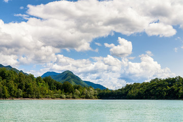 Obraz premium Mountain and fluffy clouds over lake, Slovenia