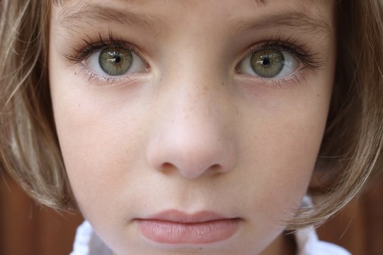 Portrait of a brown haired girl with big green eyes