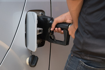Hand refilling the car with fuel at gas station