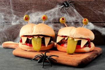 Halloween monster hamburgers on a paddle board with spider web background