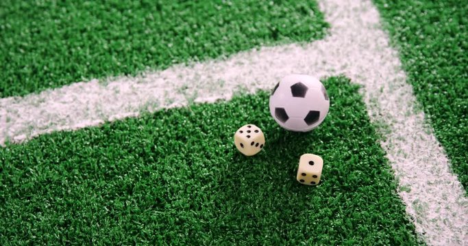Football and dice on artificial grass 