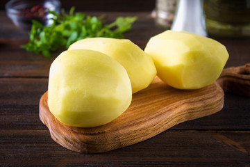 Raw peeled and sliced potatoes on an old weathered wooden table