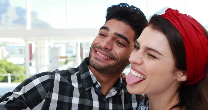 Couple taking selfie with mobile phone in office 