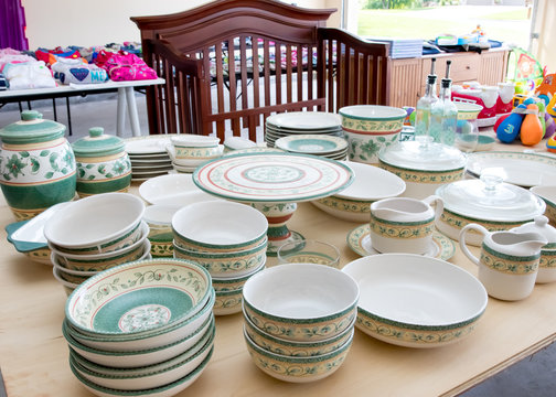 Tables Of Dishes And Baby Goods At A Suburban Garage Sale