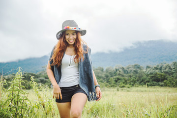 Asian women travel relax in the holiday. on a green pasture.