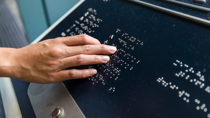 Hand touch on braille text panel - obrazy, fototapety, plakaty