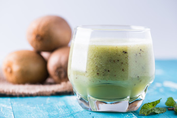 green kiwi juice, smoothie on wooden background. healthy drink in a glass. diet. summer drink and refreshment.