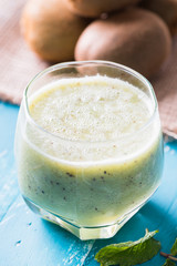 green kiwi juice, smoothie on wooden background. healthy drink in a glass. diet. summer drink and refreshment.