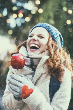 Frau mit Weihnachtsapfel auf dem Weihnachtsmarkt