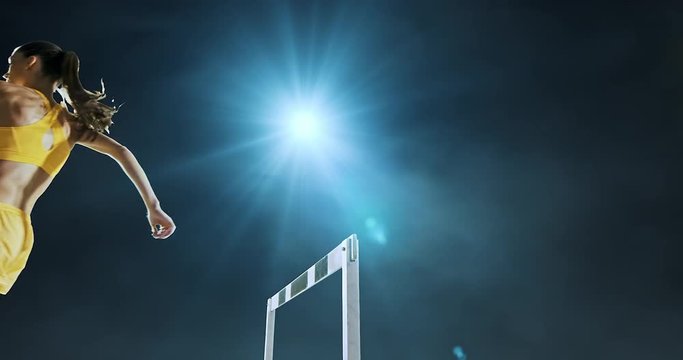 Track and field runner hurdles on sports arena