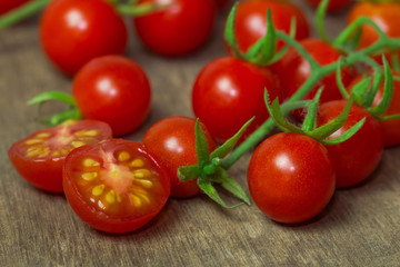 Fresh cherry tomato on rustic wood table. Close up lovely cherry tomato for background or wallpaper. Prepare fresh cut cherry tomato for home cooking look so delicious. Macro concept with copy space.