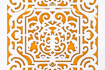 White floral perforated design on orange board. For using as pattern and background.