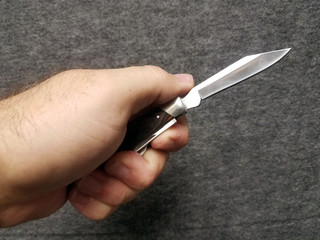 Close-up of isolated hand holding open pocket knife
