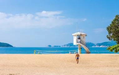 Fotobehang Tourist and enclosed lifeguard patrol tower on beach. They are at Repulse Bay in Hong Kong. © joeyphoto