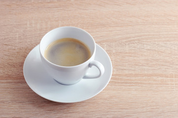 coffee in white Cup with saucer on a wooden background