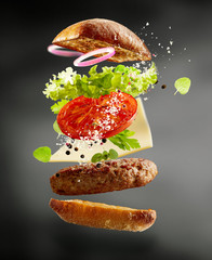 Grilled beef burger with floating ingredients