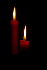 Two red candles on a black background