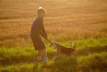 European boy playing with a Beagle on a walk