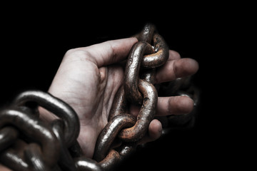 Obraz premium victim, slave, prosoner male hands tied by big metal chain by him self. People have no freedom concept image.
