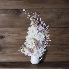Wooden background with bouquet in vase
