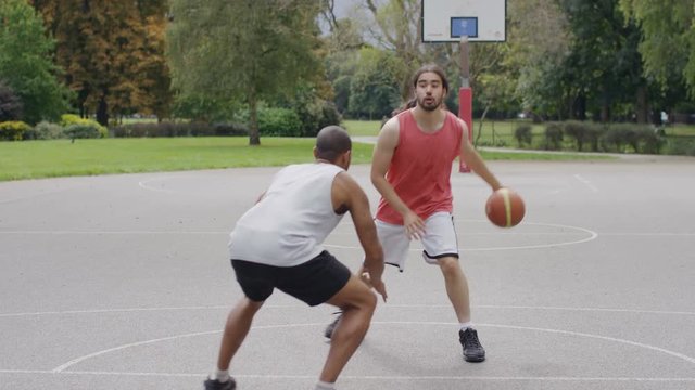 Two basketball players playing one on one outdoors