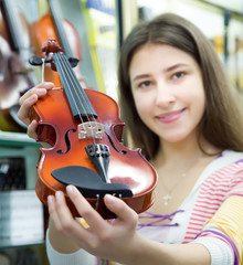 Female customer purchasing violins in store